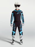 Alpinestars Supertech Vesta Jersey and Gear Set, Men's Motocross Outfit, Black and Turquoise with White Boots and Helmet.