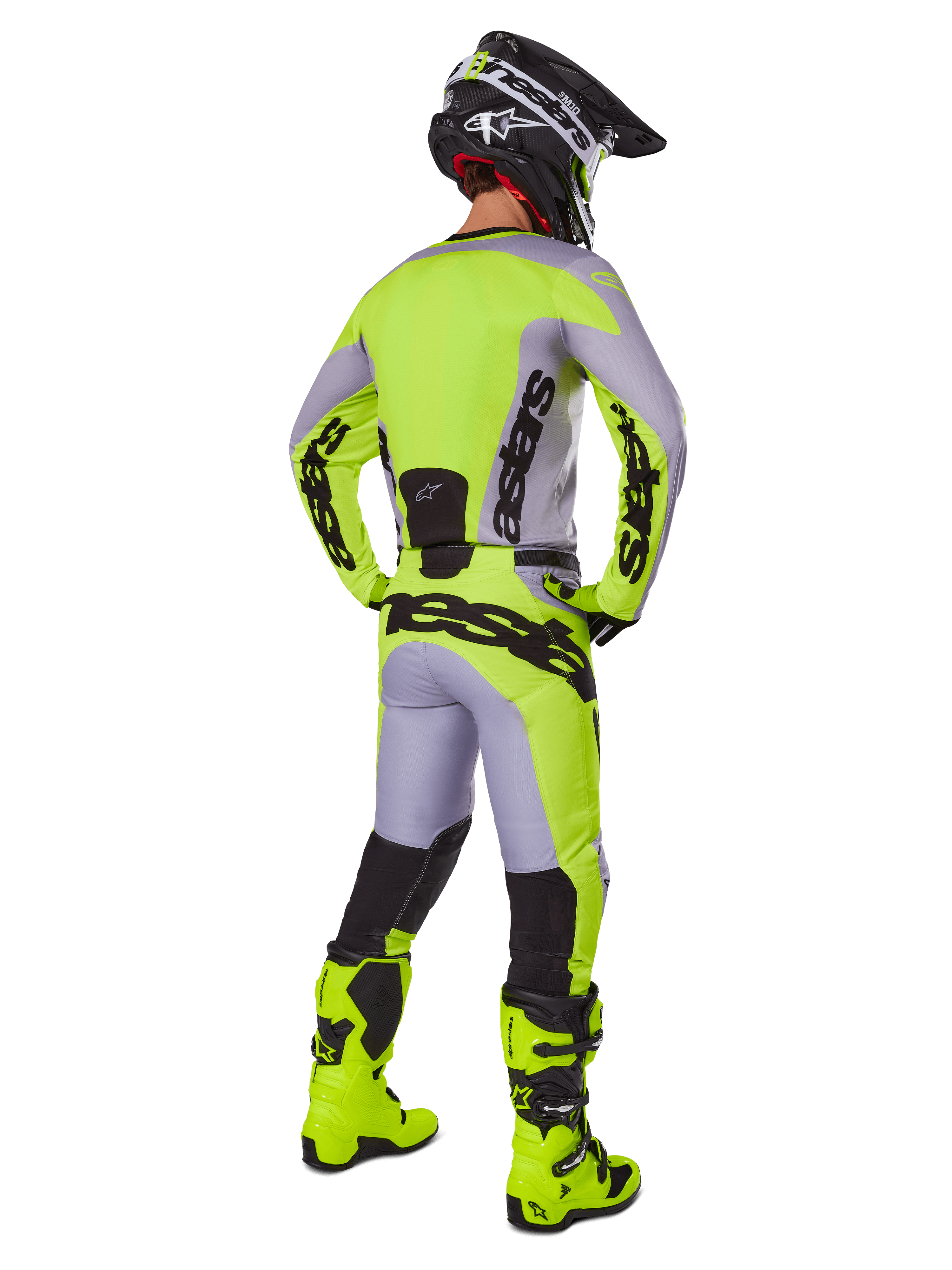 Motocross rider from behind wearing Alpinestars 2025 Racer Veil Gear Set, Gray and Yellow Fluo jersey and pants, matching fluo yellow boots and black and yellow helmet, coordinated outfit for off-road racing