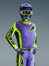 Motocross rider wearing 2026 Racer Portl Jersey, Purple and Yellow Fluo, matching purple and yellow helmet with white goggles, purple and yellow gloves, coordinated full gear set for off-road racing