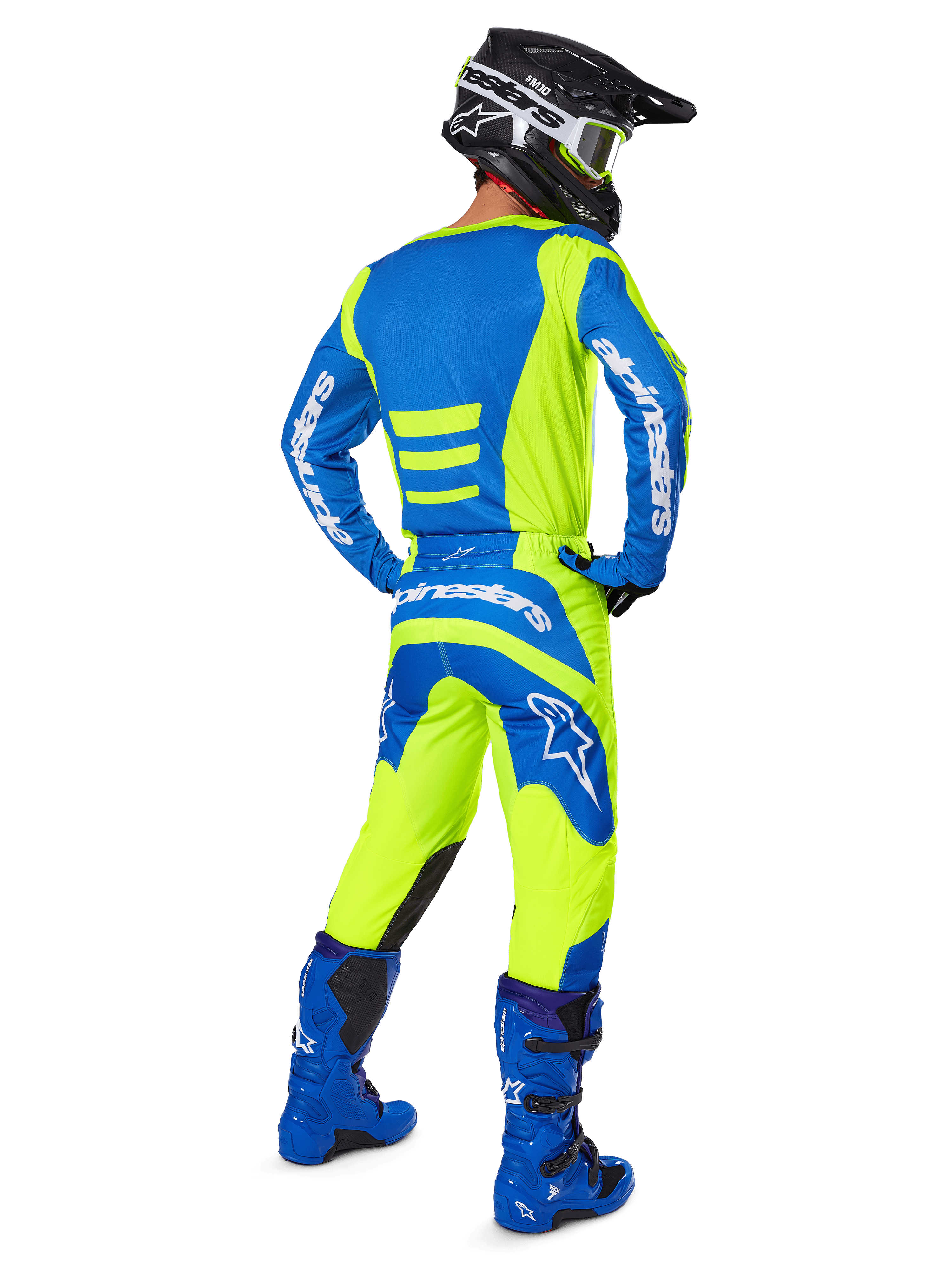 Motocross rider seen from the back wearing the Alpinestars 2025 Fluid Haul Gear Set in Yellow Fluo and Blue, featuring a blue jersey with yellow accents, yellow pants with blue panels on the seat and knees, paired with bright blue boots and a black helmet.