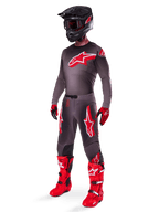 Alpinestars 2025 Supertech Lipan Gear Set, full motocross racing outfit, dark gray and red jersey with large star logo, matching pants with red accents and star graphics, red gloves, and bright red boots with white buckles, including a matte black helmet with red goggles.