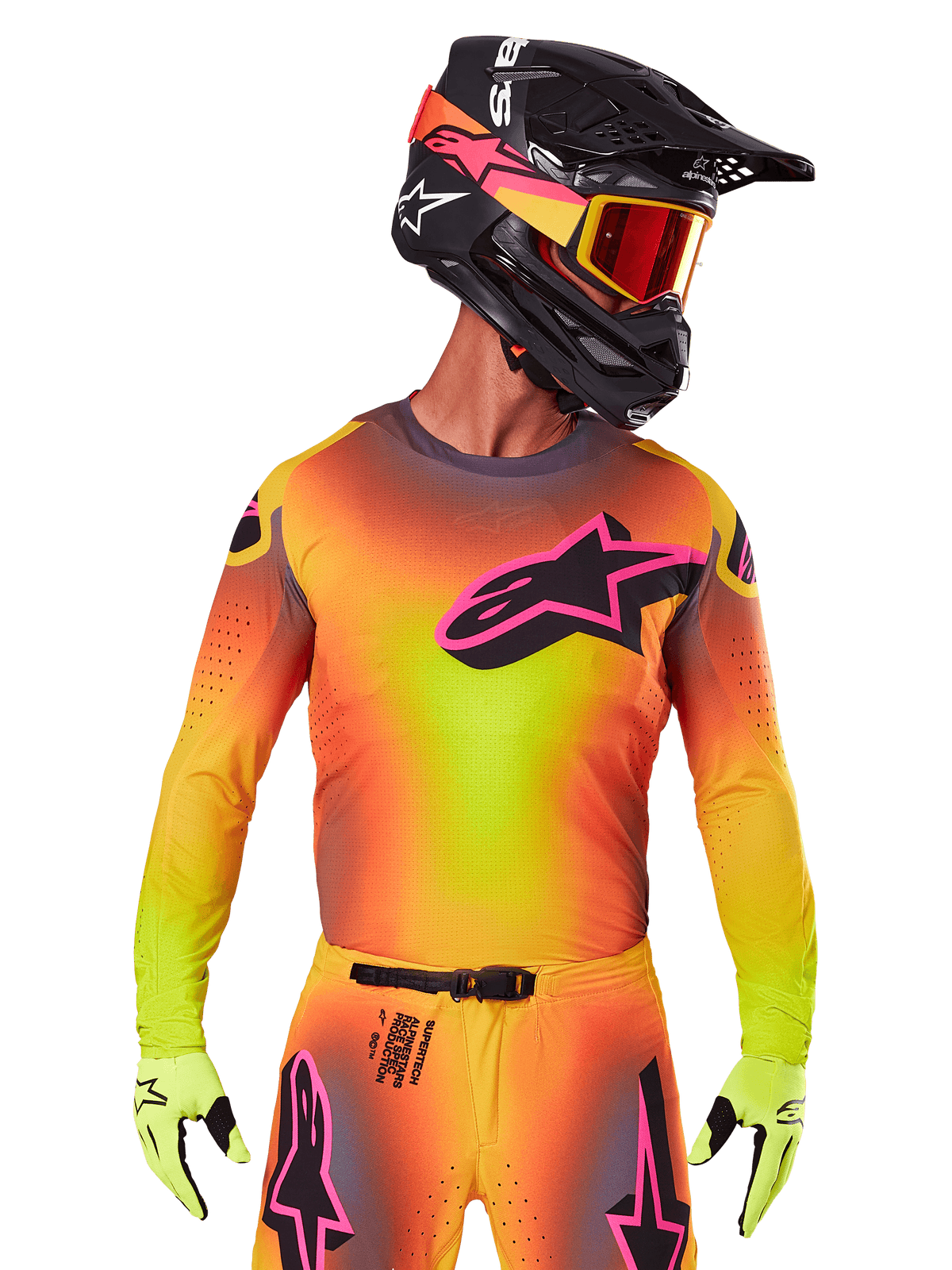 Motocross rider wearing the 2025 Supertech Lipan Jersey, vibrant yellow orange and pink gradient colorway, large black Alpinestars star logo with pink outline on the chest, laser-cut perforations for ventilation, athletic race fit, paired with matching pants, yellow gloves, and a black helmet with goggles.