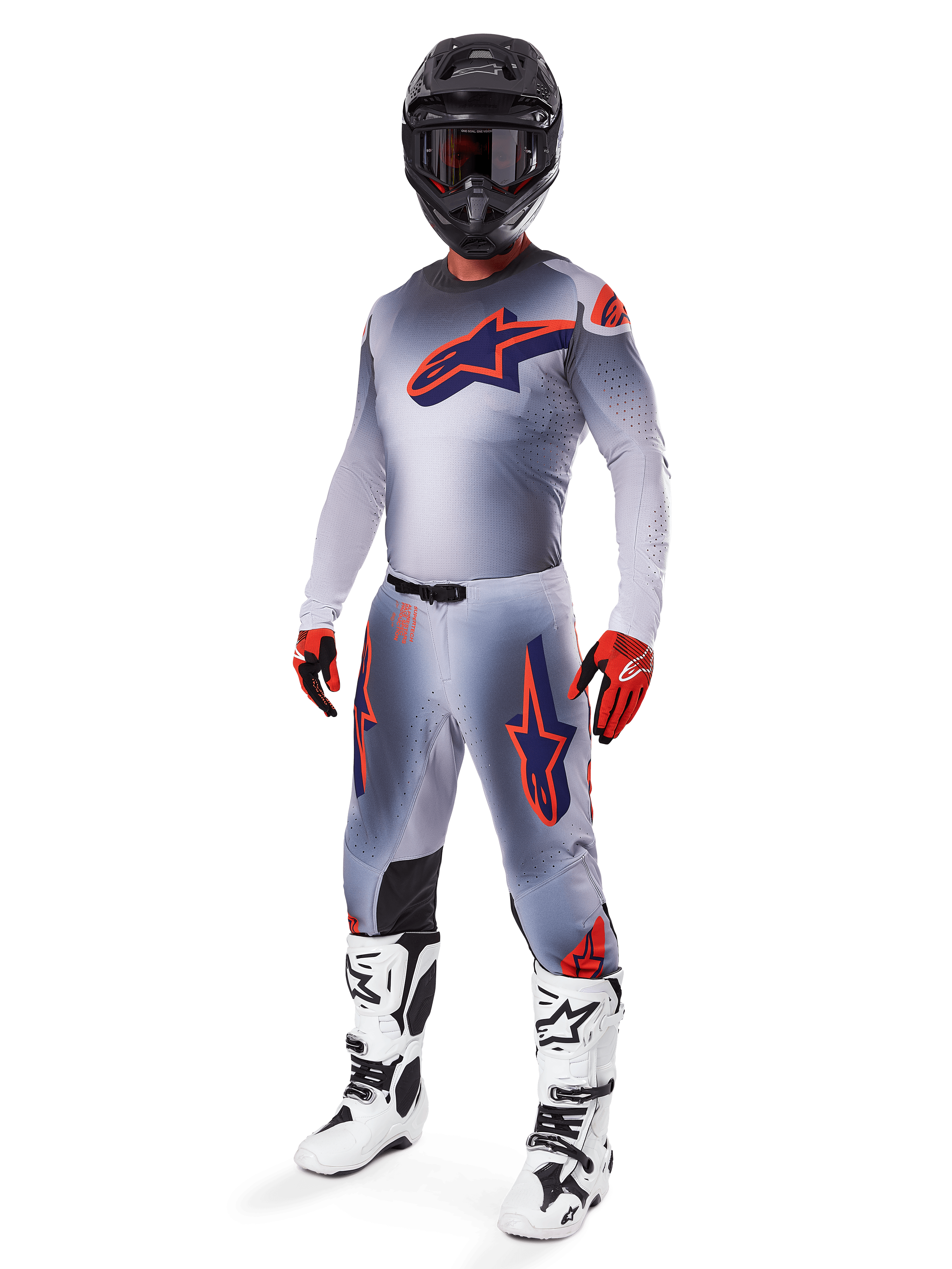 Motocross rider wearing the Alpinestars 2025 Supertech Lipan Jersey in Gray and Orange Fluo, matching gray pants with orange accents, black helmet, white and black boots, and orange and black gloves, professional gear set for off-road racing