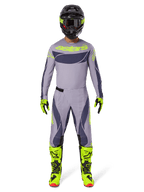 Motocross rider wearing full racing gear, 2025 Techstar Dreem Jersey in Gray and Dark Gray with neon yellow branding, matching gray and dark gray pants, neon yellow and black boots, black helmet with neon accents, coordinated outfit for professional motocross
