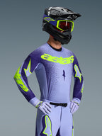 Alpinestars 2026 Supertech Scenz Gear Set, Motocross rider wearing lavender and dark purple racing gear with neon yellow accents, matching helmet and goggles, athletic pro-fit jersey and pants with bold branding
