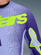 Alpinestars 2026 Supertech Scenz Jersey in Purple Yellow Fluo, close-up shot of the chest and shoulder showing laser-cut perforations, stretch mesh material, and bright yellow fluo branding for pro-level motocross performance.