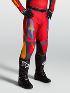 Alpinestars Racer Hunt Pants, red motocross pants for men with graystone and coral accents, on-model with black boots.
