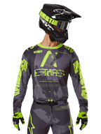 Alpinestars 2025 Racer Hollow Jersey, Motocross Racing Jersey, Dark Camo and Neon Yellow, worn with matching pants, black and yellow helmet with goggles, and black gloves, featuring Alpinestars branding and camouflage design