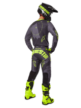 Motocross rider from the back wearing the Alpinestars 2025 Racer Hollow Jersey and Pants in Dark Camo Yellow Fluo, featuring a dark grey camo pattern with neon yellow accents, paired with a matching black and yellow helmet and bright neon yellow boots.