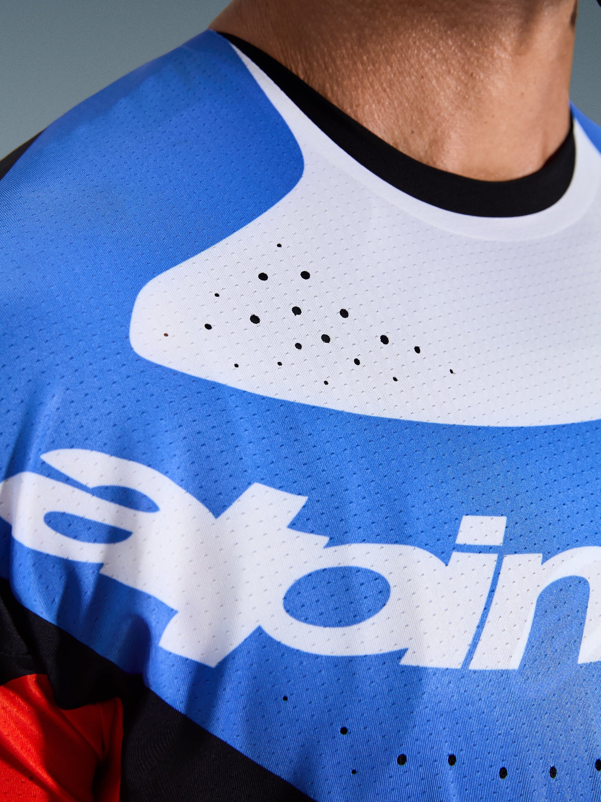 Alpinestars 2026 Techstar Knif Jersey, Motocross Jersey, close-up of chest and neck, Blue and White with black collar, laser-cut ventilation holes, breathable mesh fabric with Alpinestars logo.