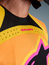 Alpinestars 2026 Techstar Nomur Jersey, Motocross Jersey, Orange Yellow Pink, close-up detail of the chest and collar, featuring laser-cut ventilation, pink branding, and breathable mesh fabric