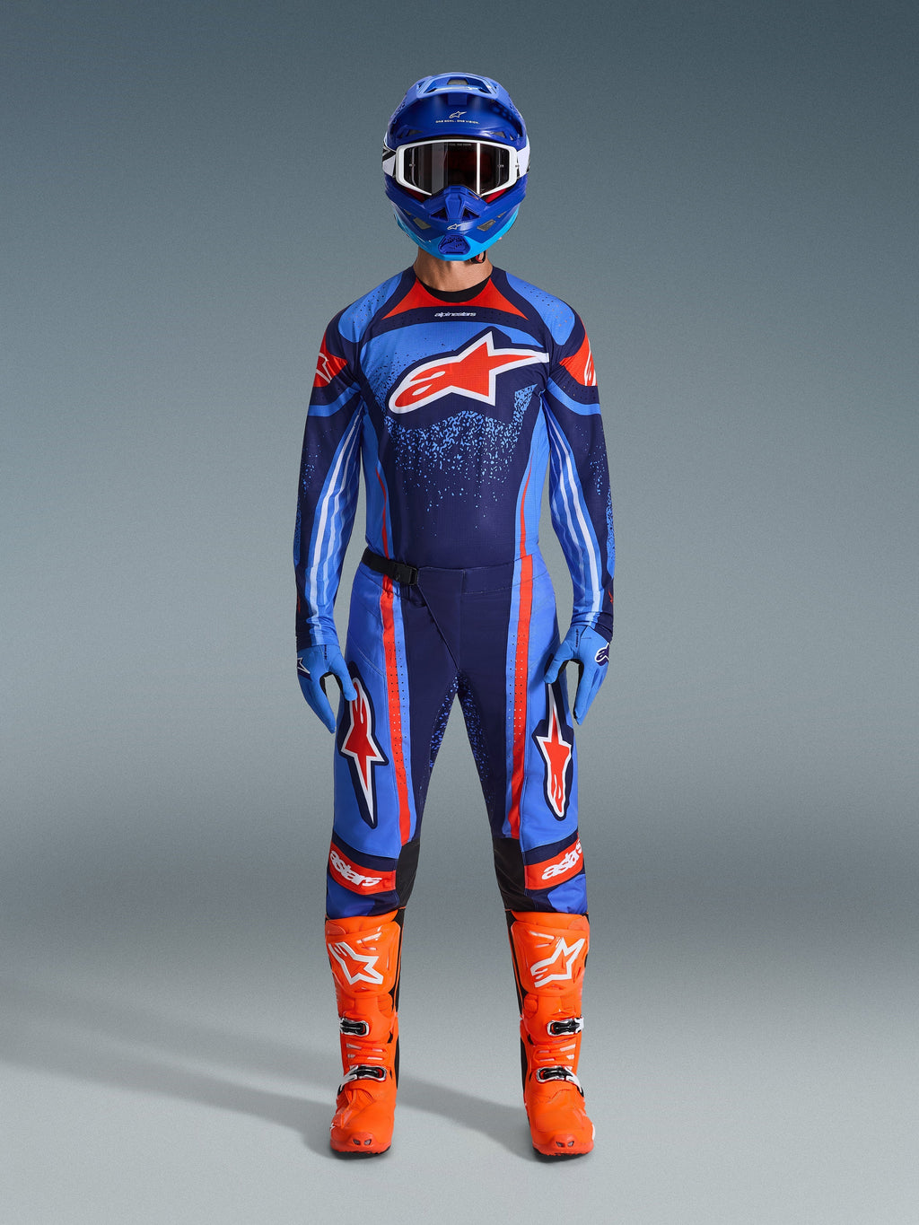 Alpinestars 2026 Techstar Nomur Gear Set, Motocross Racing Gear, Dark Navy, Orange and UCLA Blue, complete riding outfit with blue helmet, matching jersey and pants, blue gloves, and bright orange boots, featuring star logos, performance off-road protection