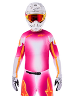 Alpinestars Limited Edition Supertech AFD MIG Jersey, Pink Fluo White Motocross Jersey, featuring a vibrant gradient with orange star logos, worn as a complete racing kit with matching pants, white helmet, and red goggles, professional dirt riding apparel