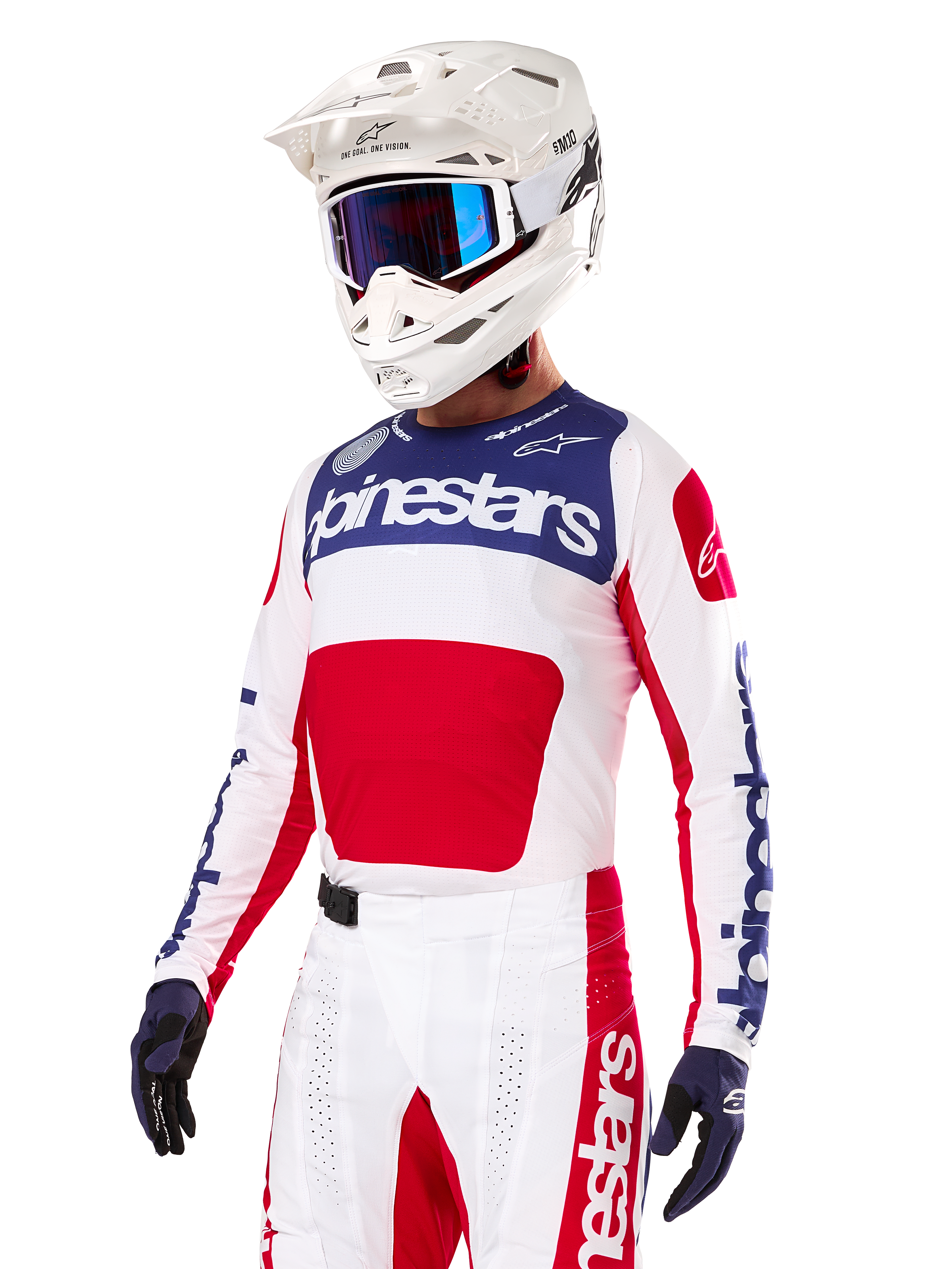 Motocross rider wearing the Alpinestars Limited Edition Techstar Fortitude Jersey, Bright Red White and Blue, featuring a white helmet with blue goggles and matching pants, high-performance racing apparel for off-road competition