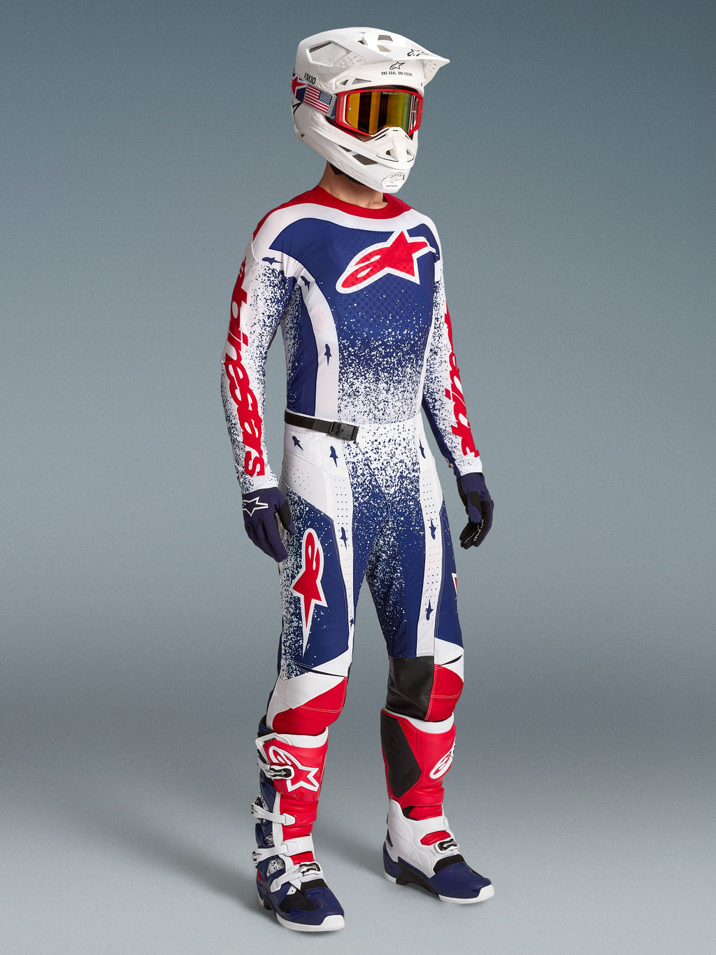 Alpinestars Limited Edition Techstar Unity men's motocross gear set in red, white, and blue with racing boots and helmet.