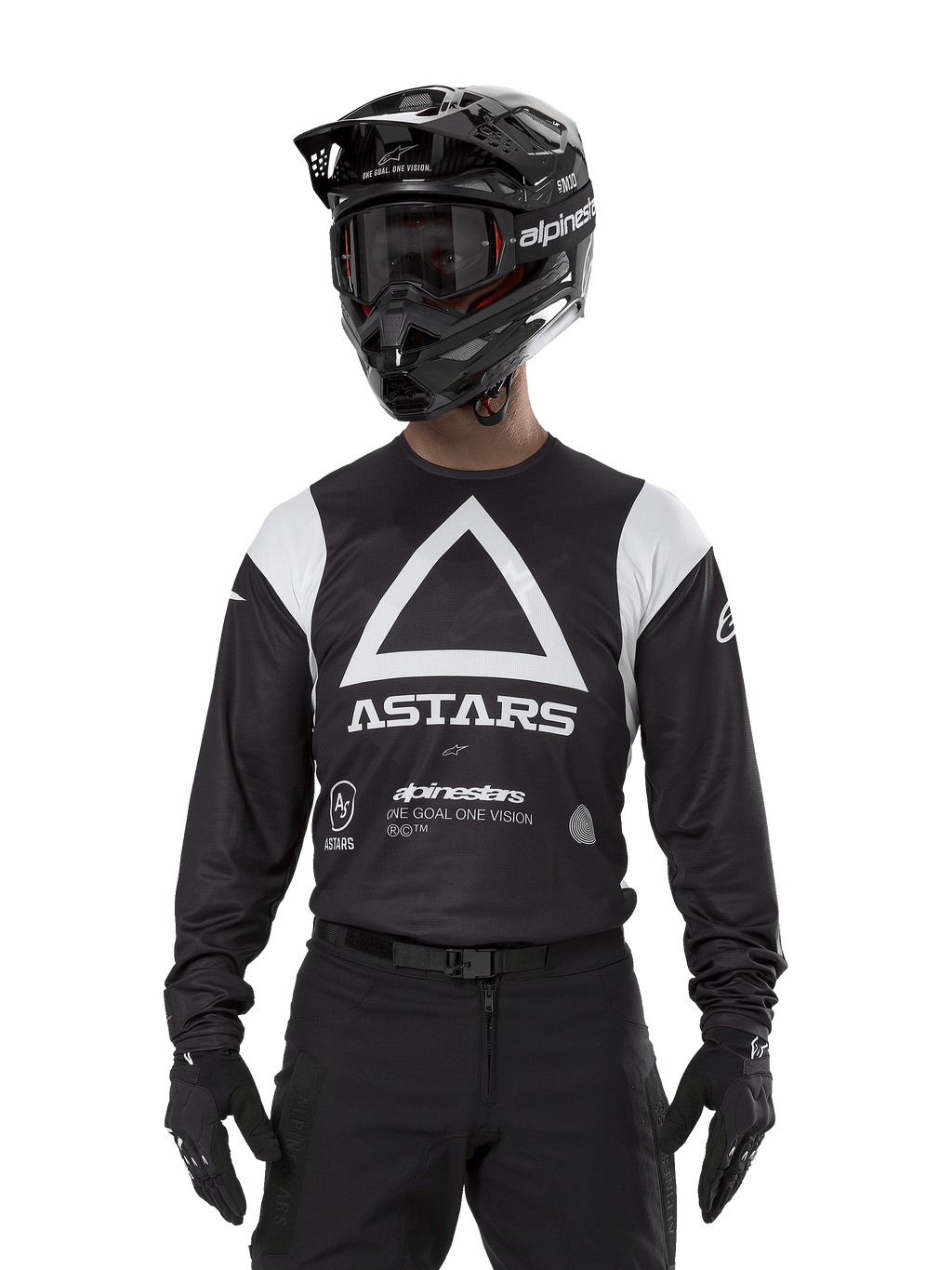 Alpinestars Techdura Jersey, Black, featuring a large white triangle chest graphic with ASTARS logo and white shoulder panels, worn by a rider with a black motocross helmet, goggles, and matching black off-road gear.