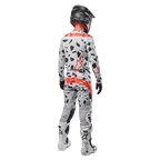 Motocross rider from behind wearing Alpinestars 2024 Techstar Rantera Jersey and matching pants, Haze Gray Camo pattern with bold red Alpinestars logos, black helmet, white and black boots, black gloves, coordinated motocross gear set.