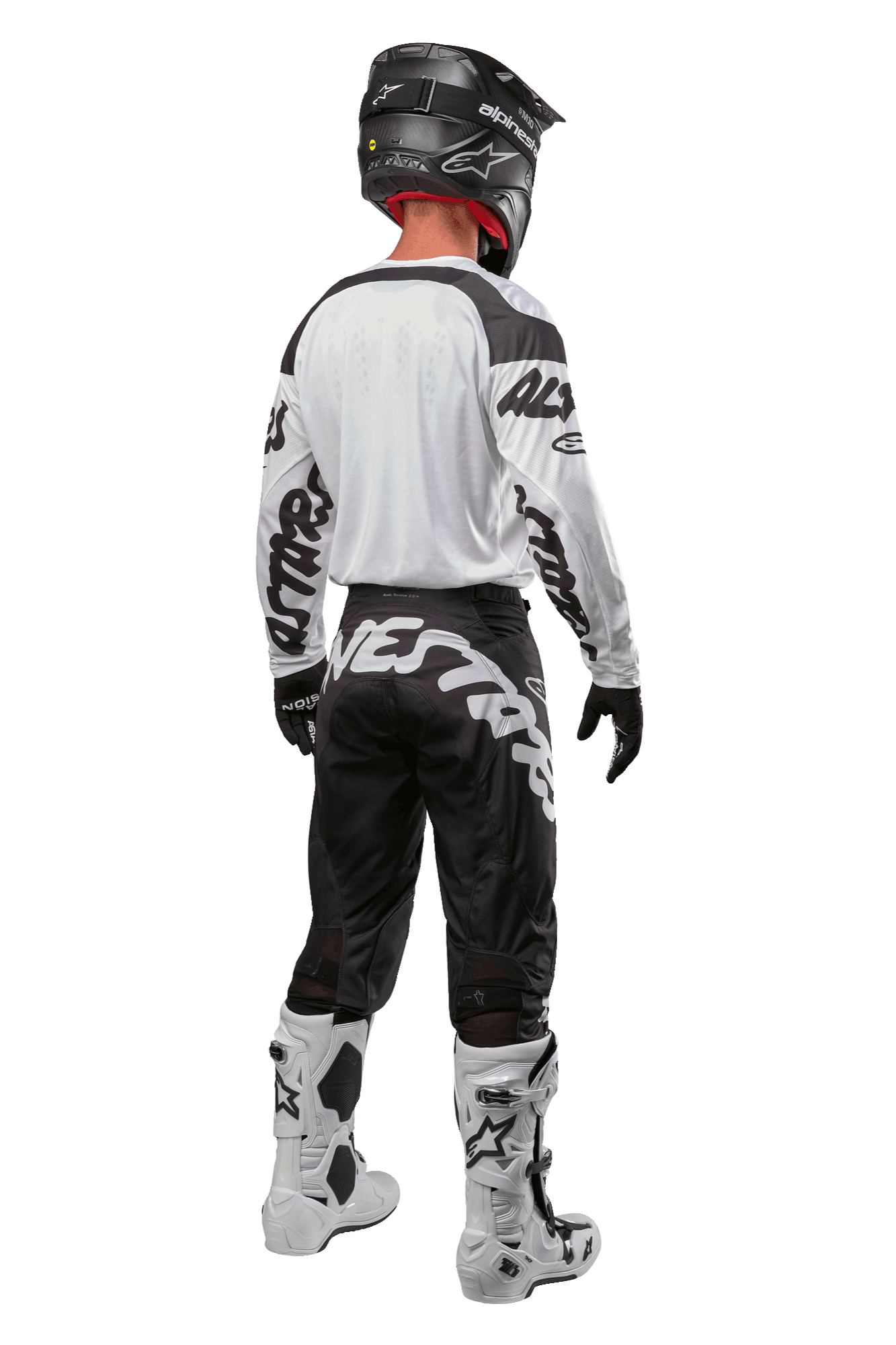 Alpinestars 2024 Racer Hana Jersey, back view of motocross rider, White and Black, white jersey with black graphic branding on sleeves, paired with black pants featuring white Alpinestars lettering on the seat, black helmet, and white and black boots, coordinated off-road racing gear
