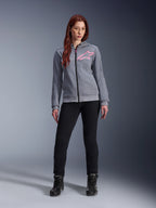 Alpinestars Stella Chrome V2 Sport Hoodie, Gray Heather Pink Fluo, worn by a woman with black pants and boots, featuring a pink Alpinestars star logo on the chest, full-zip urban motorcycle gear, lightweight tech fleece with a casual athletic fit.