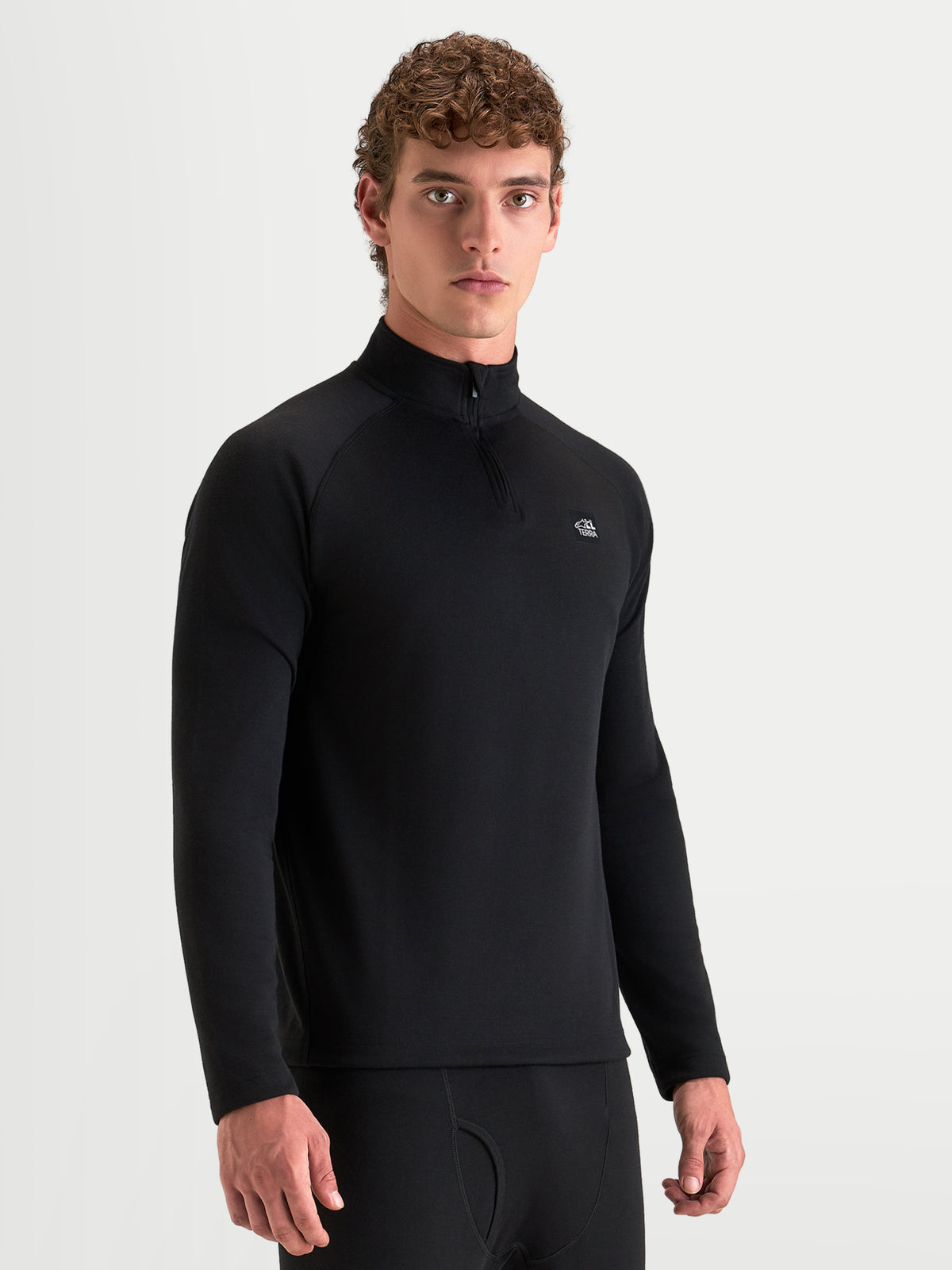 Alpinestars AT-8 Merino Top Layer, men's adventure motorcycle base layer in black, long-sleeve tech layer with a half-zip collar worn by a model.
