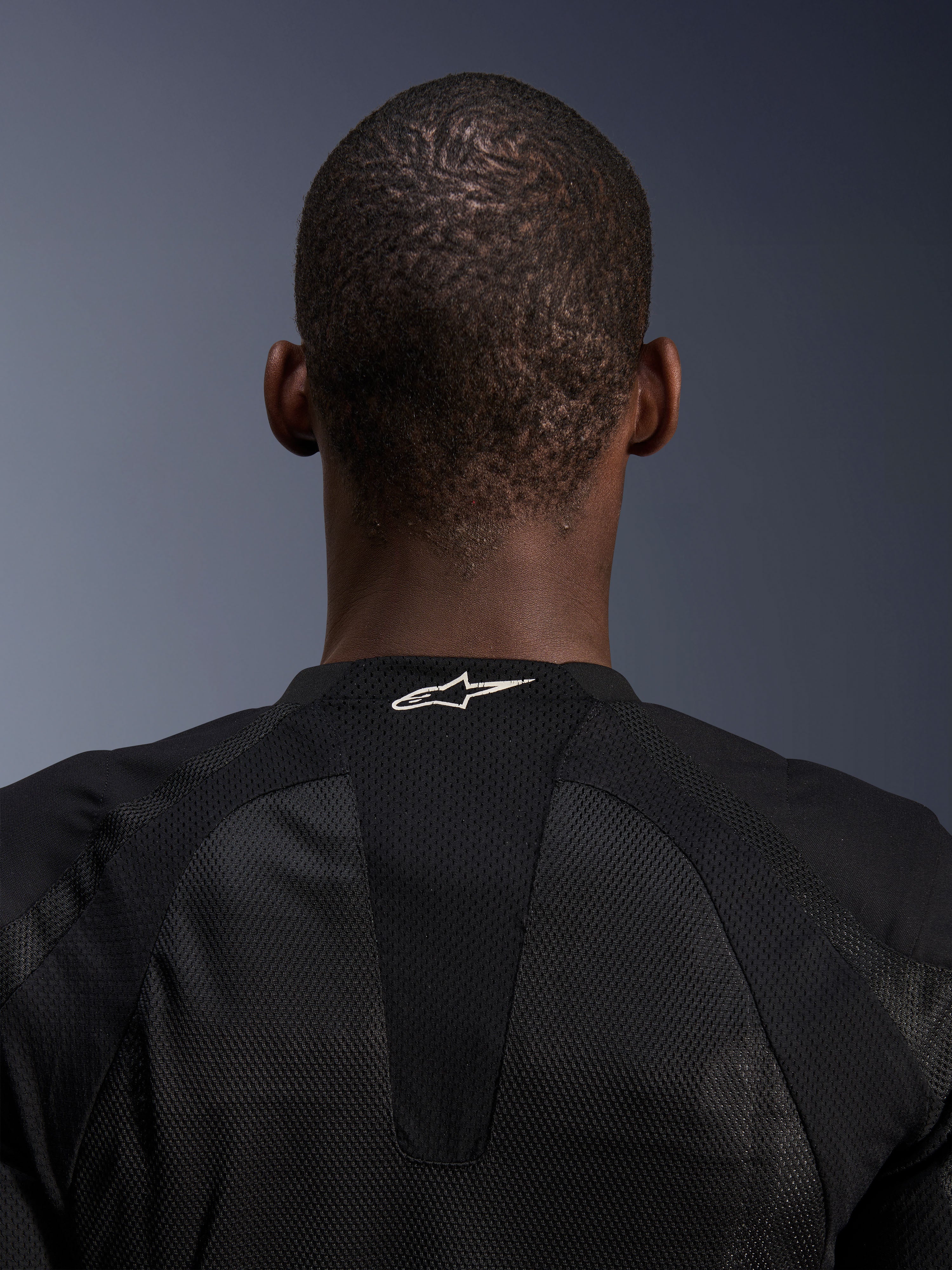 Alpinestars Troop-Air Jacket, Black, close-up of the back neck showing a white Alpinestars logo on breathable tech mesh, technical motorcycle jacket designed for maximum airflow