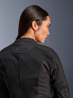 Alpinestars Woman Stella C-1 Air Jacket, Textile Motorcycle Jacket, Black, close-up rear view showing tech mesh ventilation panels and a reflective star logo on the upper back, modern urban riding gear