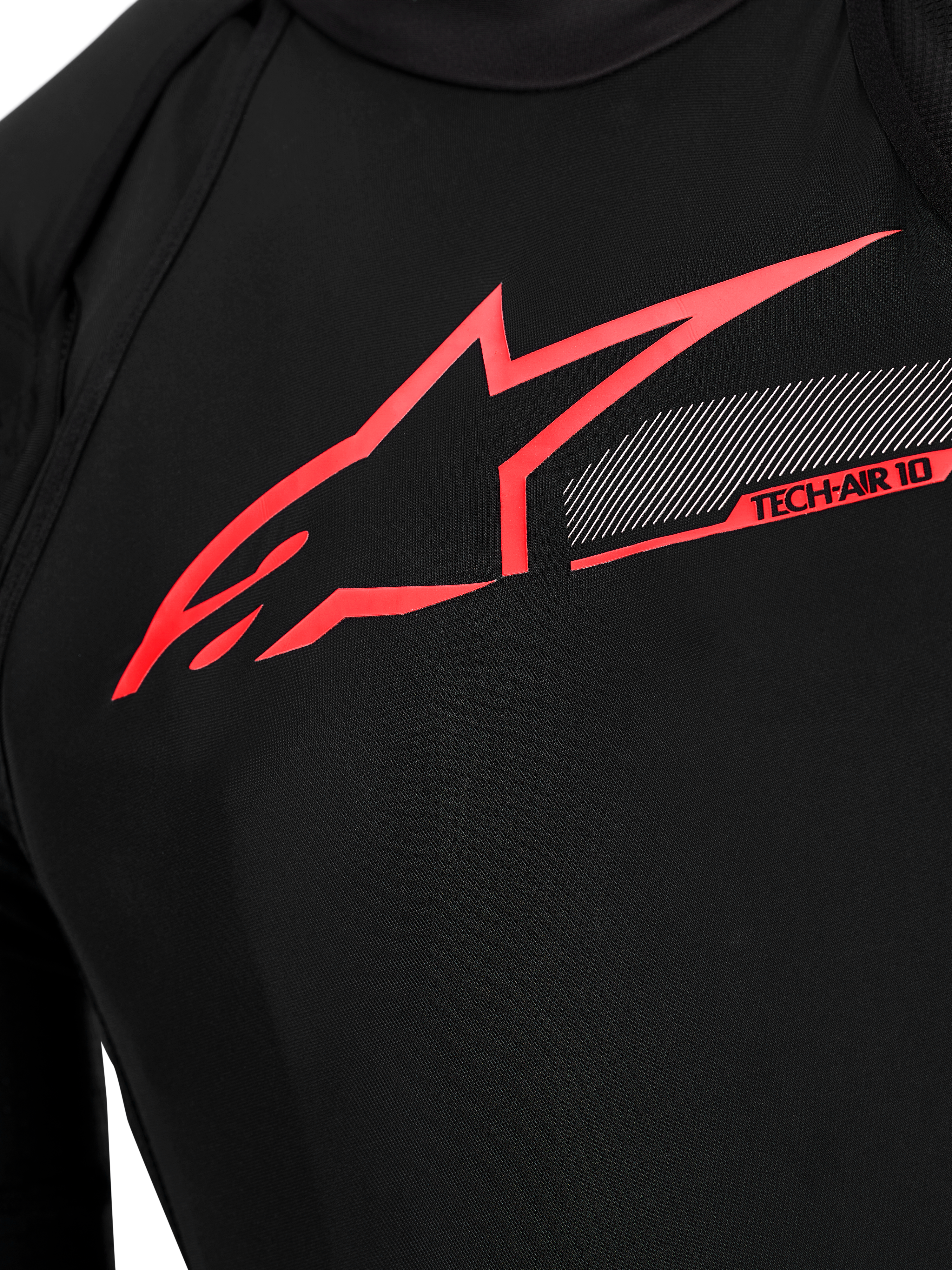 Tech-Air 10 V2 Race Airbag System chest detail, black technical fabric with bright red Alpinestars logo and tech graphics.