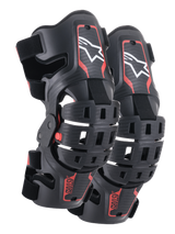 Alpinestars Youth Bionic 5S Knee Braces, Motocross Knee Protection, Black and Red, pair of protectors featuring a hybrid frame design with ventilated shells, white Astar logo on the upper section, red ASTARS branding on the lower section, and adjustable black straps for a secure fit.