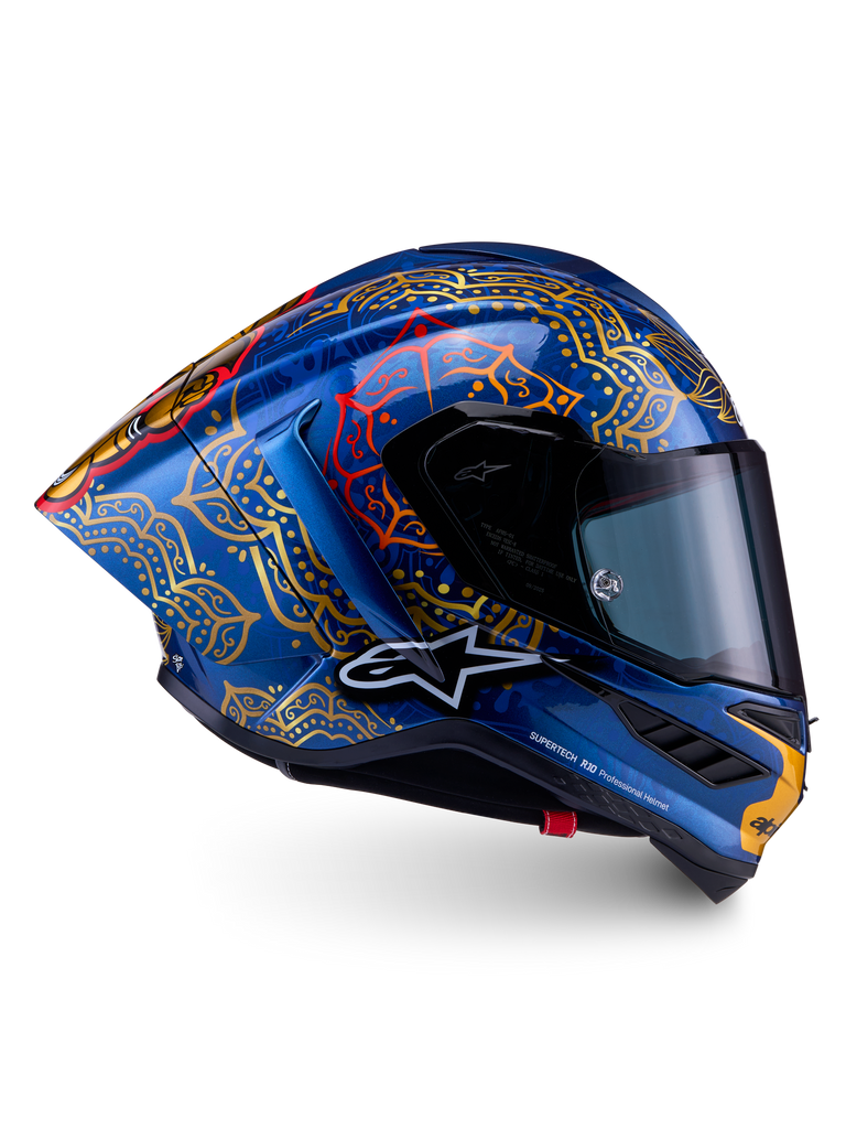 Supertech R10 Martinator Thai Helmet in glossy blue carbon with intricate gold mandala graphics and a racing profile.