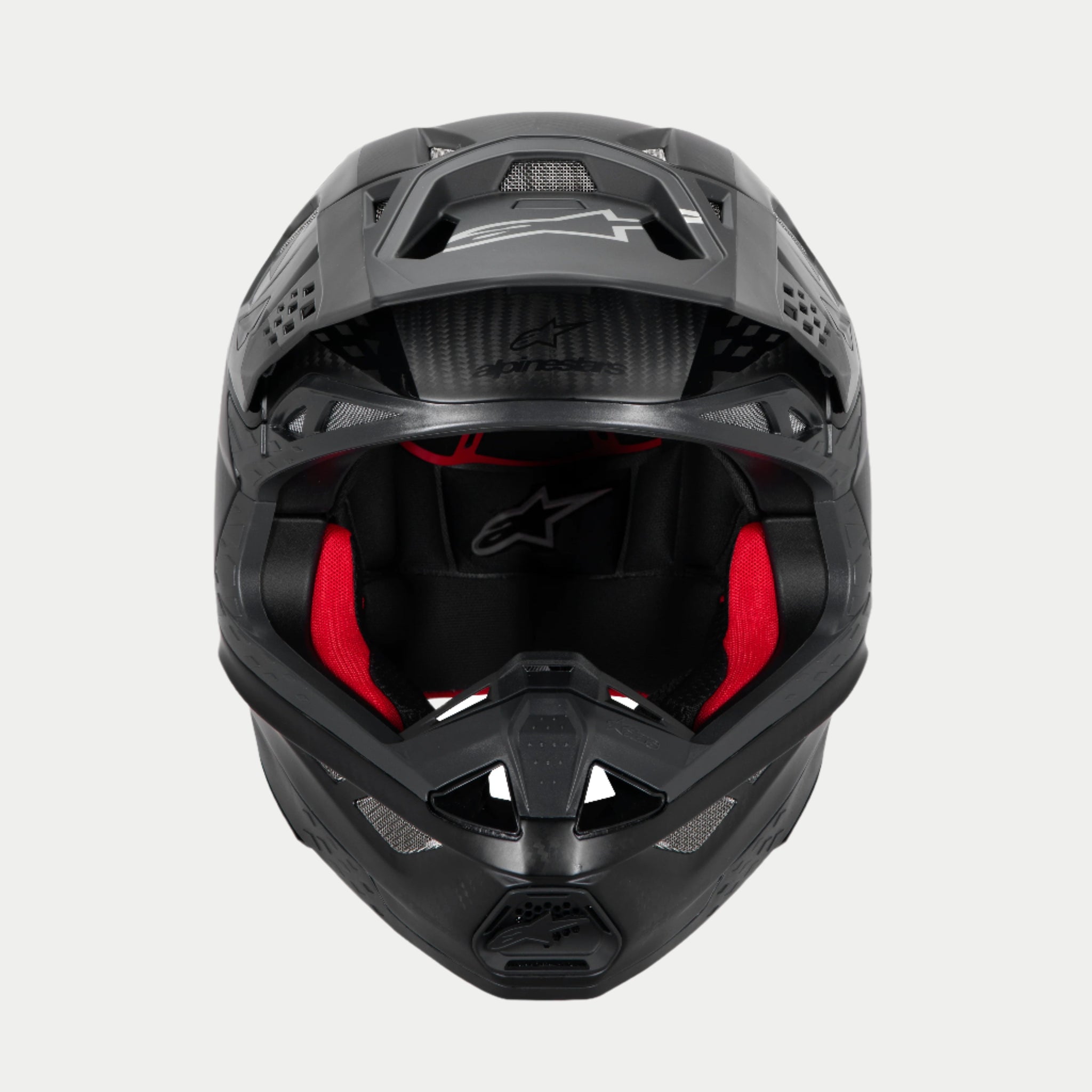 Alpinestars Supertech M10 Fame ECE 22.06 Helmet, Motocross Helmet, Black Carbon Matte and Glossy, front view with visible red interior padding, aerodynamic carbon fiber shell, ventilated design for off-road racing
