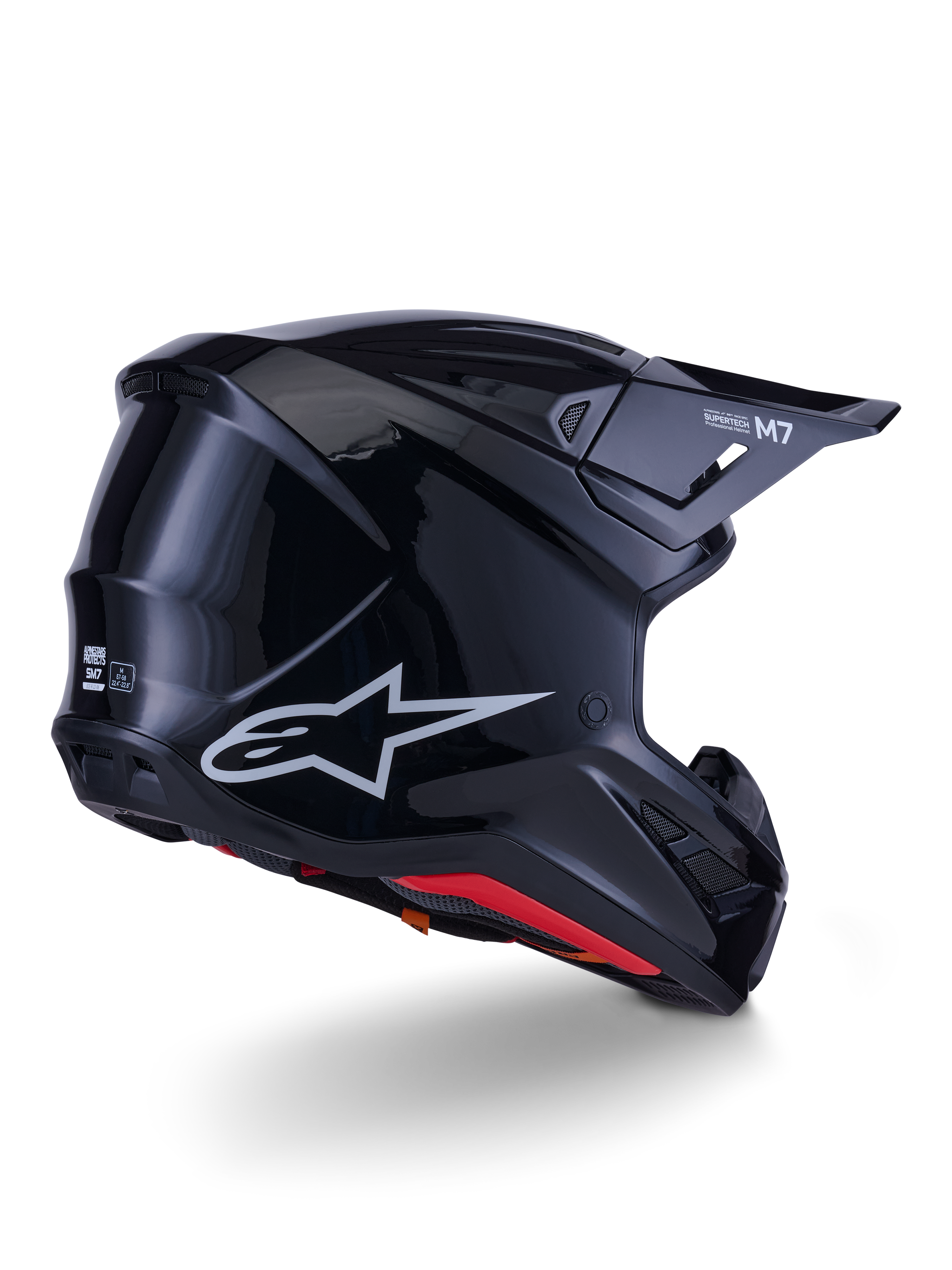 Alpinestars S-M7 Solid Helmet, Motocross Helmet, Glossy Black, featuring a sleek aerodynamic shell with a silver Astars logo, red interior trim, and integrated ventilation ports, designed for off-road racing protection