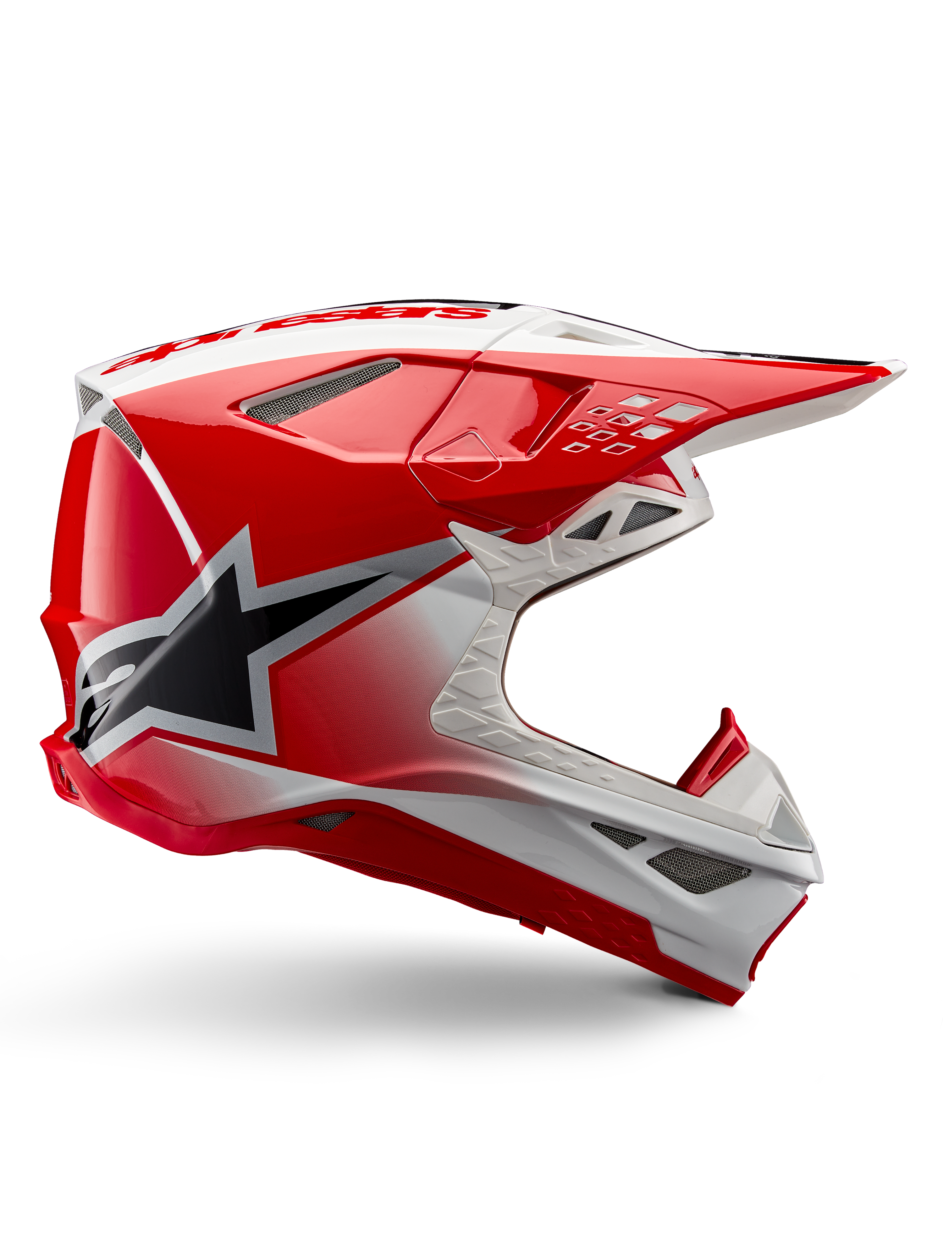 Alpinestars Supertech M10 Unite Helmet, Motocross Racing Helmet, Red and White Glossy, featuring a side view with angular geometric patterns, black star graphic, multiple mesh air vents, and aerodynamic design for off-road racing