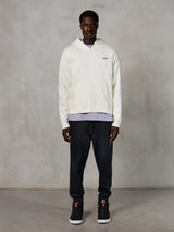 Alpinestars Essentials Ageless Zip Hoodie, casual streetwear, off-white with subtle black chest logo, full-zip front, hooded design, relaxed fit, styled with black sweatpants and sneakers