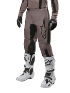 Alpinestars 2024 Fluid Lurv Pants, Motocross Pants, Mud Black and Black, featuring Alpinestars logo, worn with black gloves and white motocross boots, sporty design for off-road racing