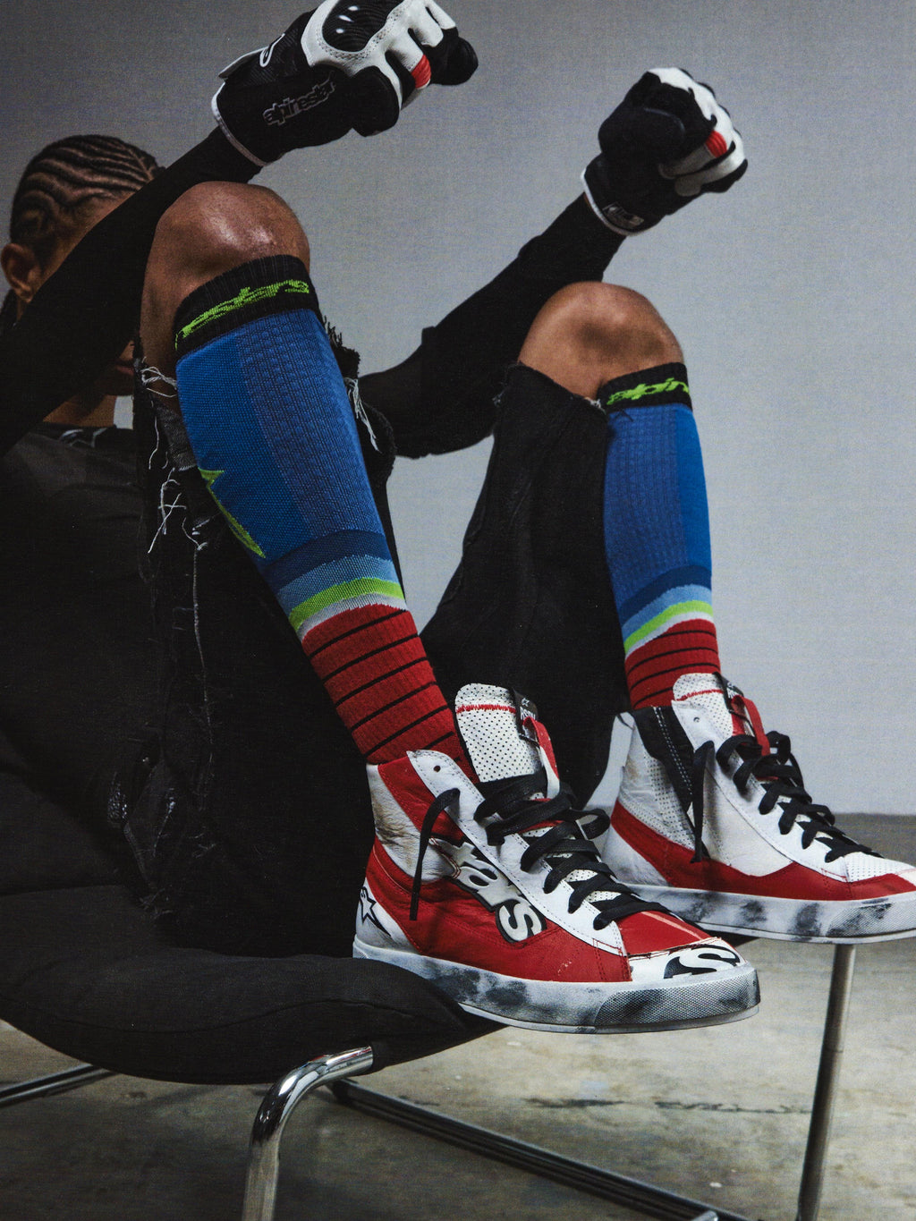 Alpinestars RSRV Legacy Shoe, Red White and Black High-Top Sneakers, Premium Lifestyle Footwear, Worn Texture with Black Scuffs, Person Wearing Colorful Striped Socks and Black Gloves