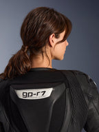 Alpinestars Stella GP-R7 2-Piece Leather Suit, Black, close-up view of the back featuring the GP-R7 logo on the aerodynamic hump, leather accordion stretch panels on shoulders, premium race-grade construction for women.