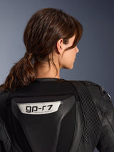 Alpinestars Stella GP-R7 2-Piece Leather Suit, Black, close-up view of the back featuring the GP-R7 logo on the aerodynamic hump, leather accordion stretch panels on shoulders, premium race-grade construction for women.