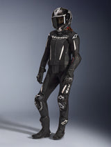 Alpinestars Stella GP-R7 2-Piece Leather Suit, Women's Motorcycle Suit, Black with white accents, worn by a female rider with a full-face racing helmet, black gloves, and boots, featuring perforated leather panels and white Alpinestars branding, professional racing and sport performance gear