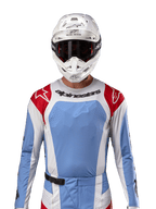 Alpinestars 2024 Techstar Ocuri Jersey, Motocross Racing Jersey, Light Blue Mars Red and White, front view featuring laser-cut ventilation and athletic fit, worn with a white helmet and goggles for a professional off-road racing look