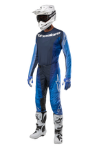 Alpinestars 2024 Techstar Pneuma Pants, Motocross Pants, Dark Navy and Light Blue, full racing kit featuring matching jersey, white helmet with goggles, blue and white gloves, and white boots, professional off-road gear setup