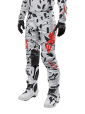 Alpinestars 2024 Techstar Rantera Pants, Motocross Pants, Haze Gray Camo with black and red abstract pattern, worn with matching jersey, black gloves, and white motocross boots, designed for high-performance off-road racing