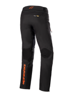 Alpinestars AMT-10R Drystar® XF Pants, Black with orange accents, rear view showing vertical orange Alpinestars logo on the left leg, textured knee panels, and Kevlar and Matryx branding, technical adventure touring motorcycle pants.