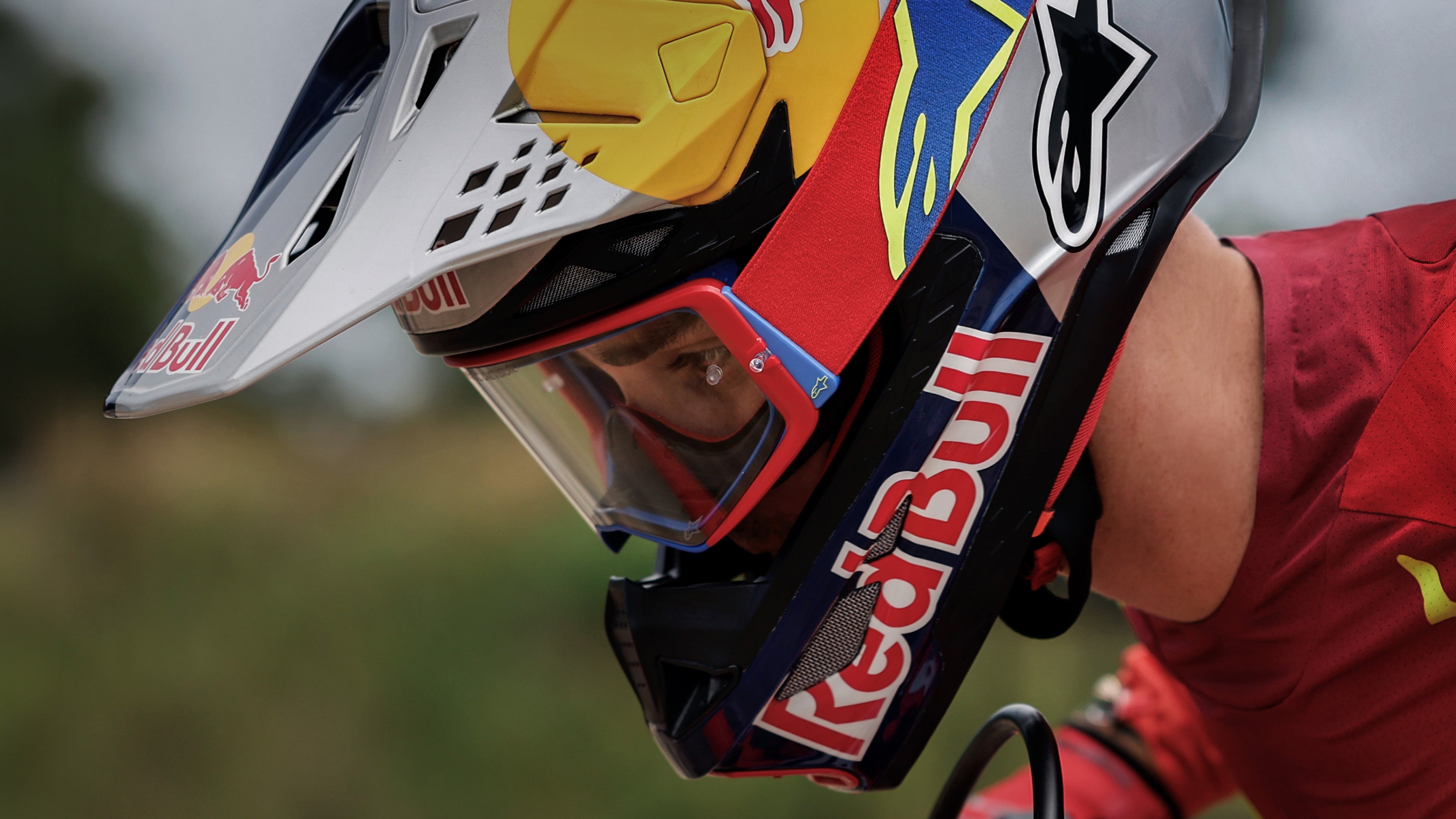 Alpinestars Motocross Helmet and Goggles, Silver and Red with Red Bull graphics, professional off-road racing gear.