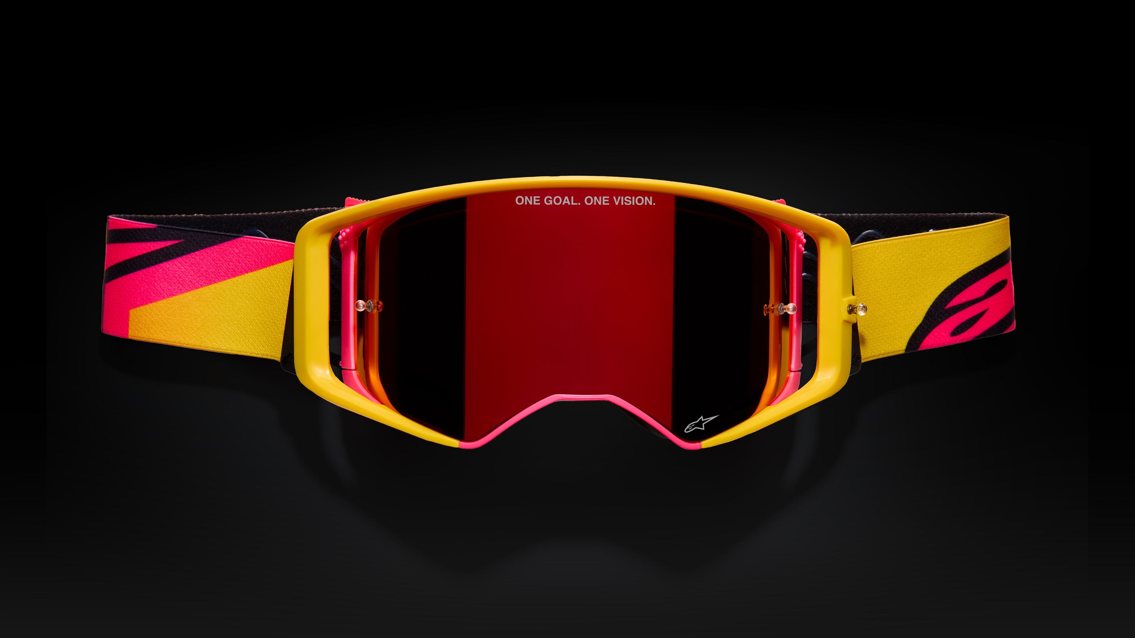 Alpinestars Wide Vision Motocross Goggles, yellow and pink frame with mirrored red lens and 'ONE GOAL. ONE VISION.' branding.