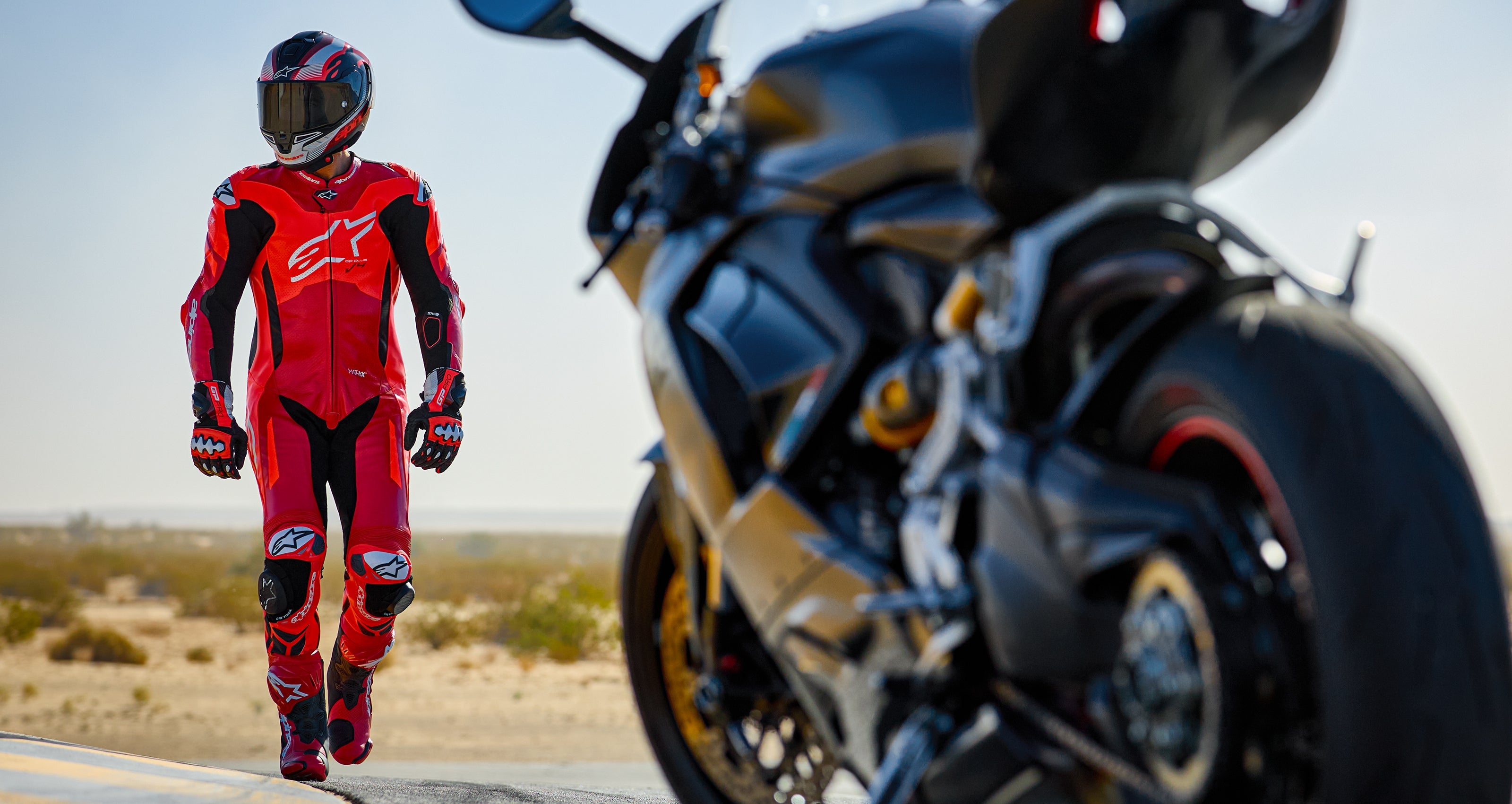 Alpinestars Gp Plus V4 Sprint Leather Suit - 1 Piece, Red Fluo and Black racing gear, worn by a rider on a track.